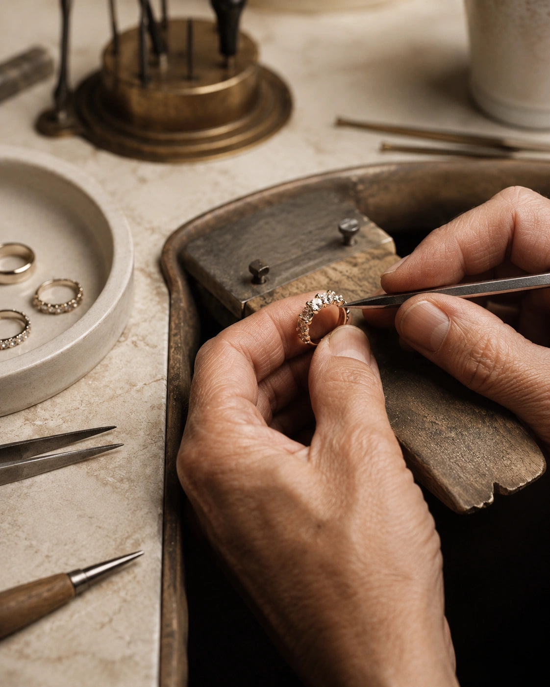 Experienced jeweler hand-setting stones on a diamond ring during the fine jewelry craftsmanship process.