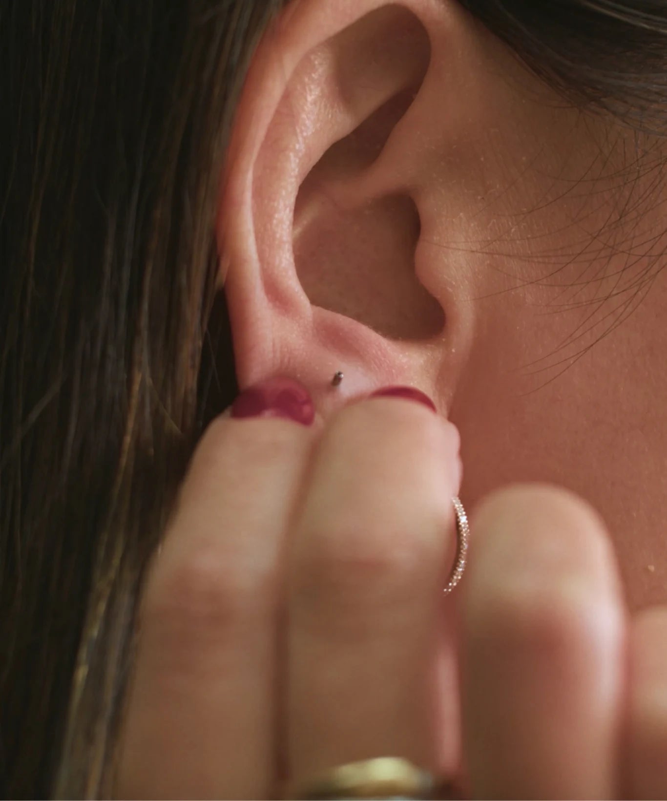 Step 1 showing a flat back stud post being inserted through the back of the ear for the LeMing flat back studs guide.