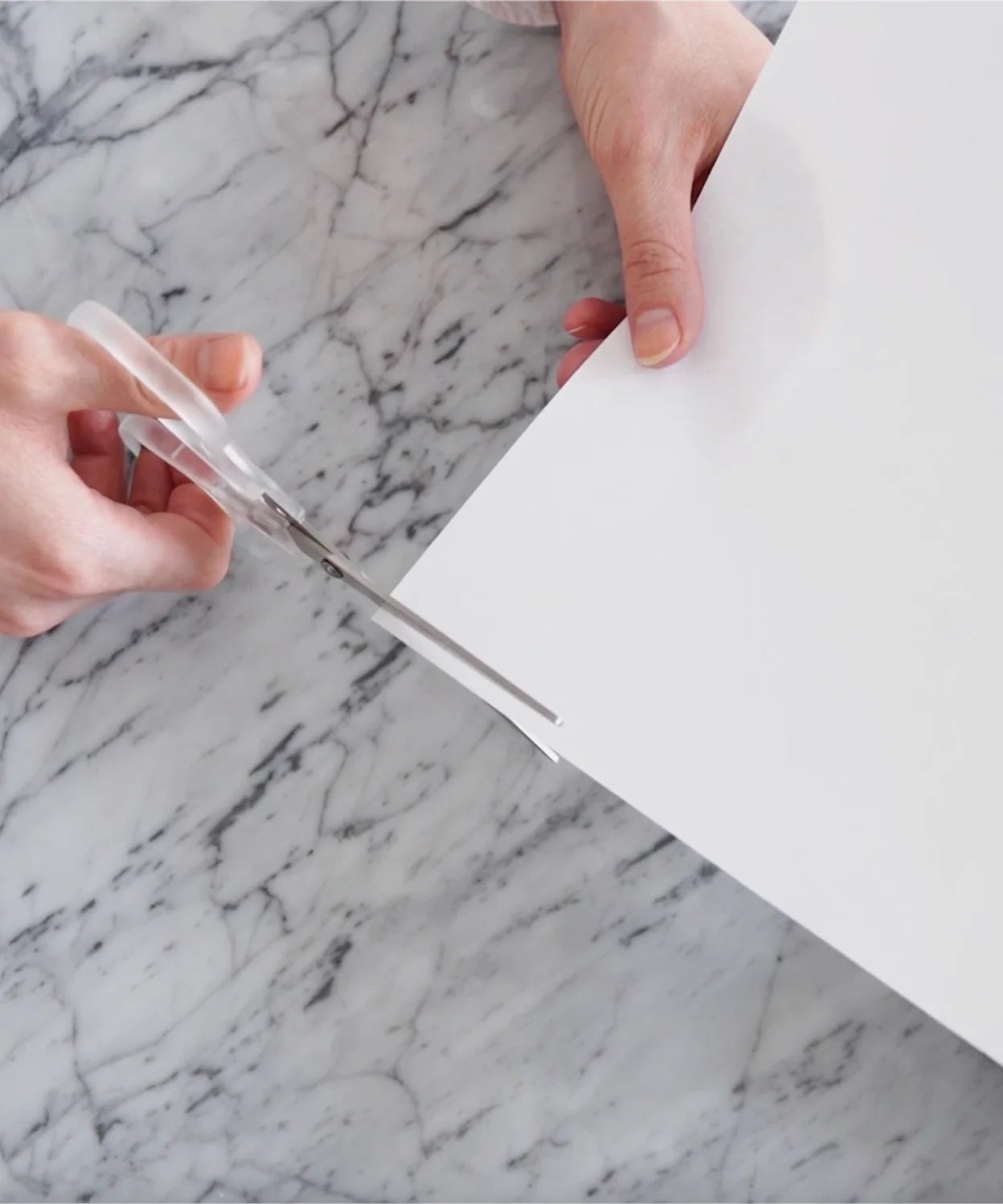 Paper strip wrapped around a finger, showing how to measure finger size at home for a LeMing ring.