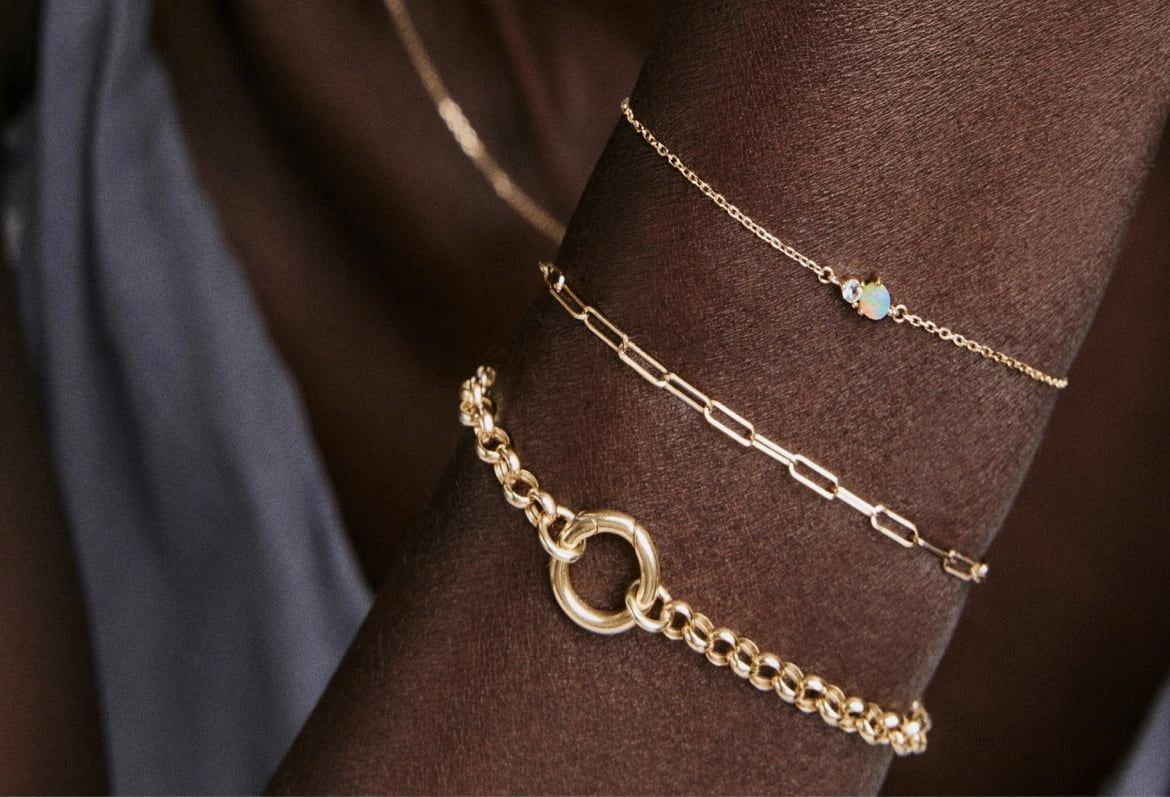Gold bracelets layered on a model’s wrist, showing bracelet fit and styling for the LeMing jewelry size guide.