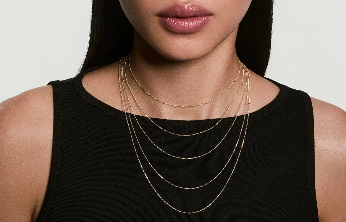 Layered gold necklaces worn on a model, showing necklace length options for the LeMing jewelry size guide.