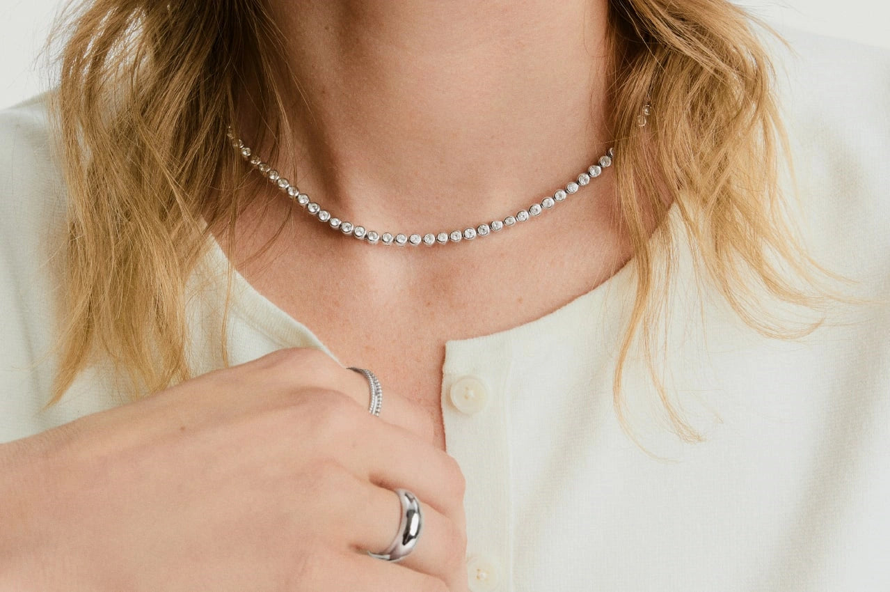 Diamond necklace and silver rings worn by a model, showing necklace length and ring fit for the LeMing size guide.