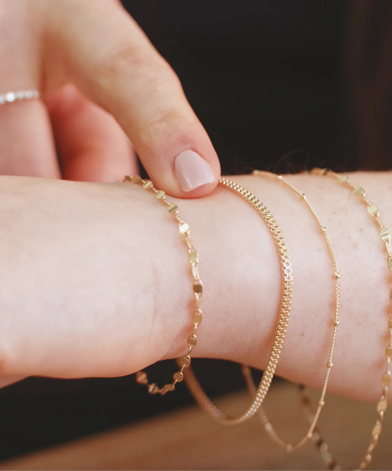 Gold bracelets worn on a wrist while checking the fit, showing how to choose a comfortable LeMing bracelet size.