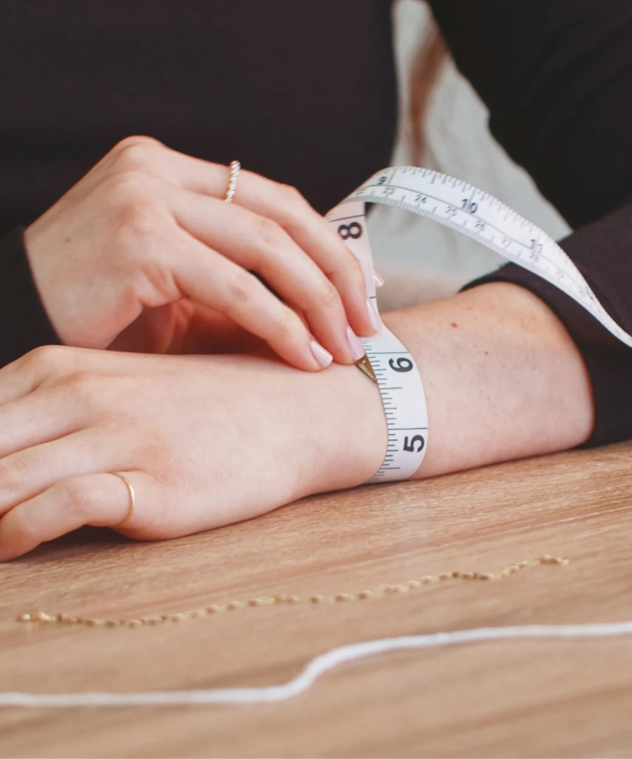 Measuring tape wrapped around a wrist, showing how to measure wrist size for the LeMing bracelet size guide.