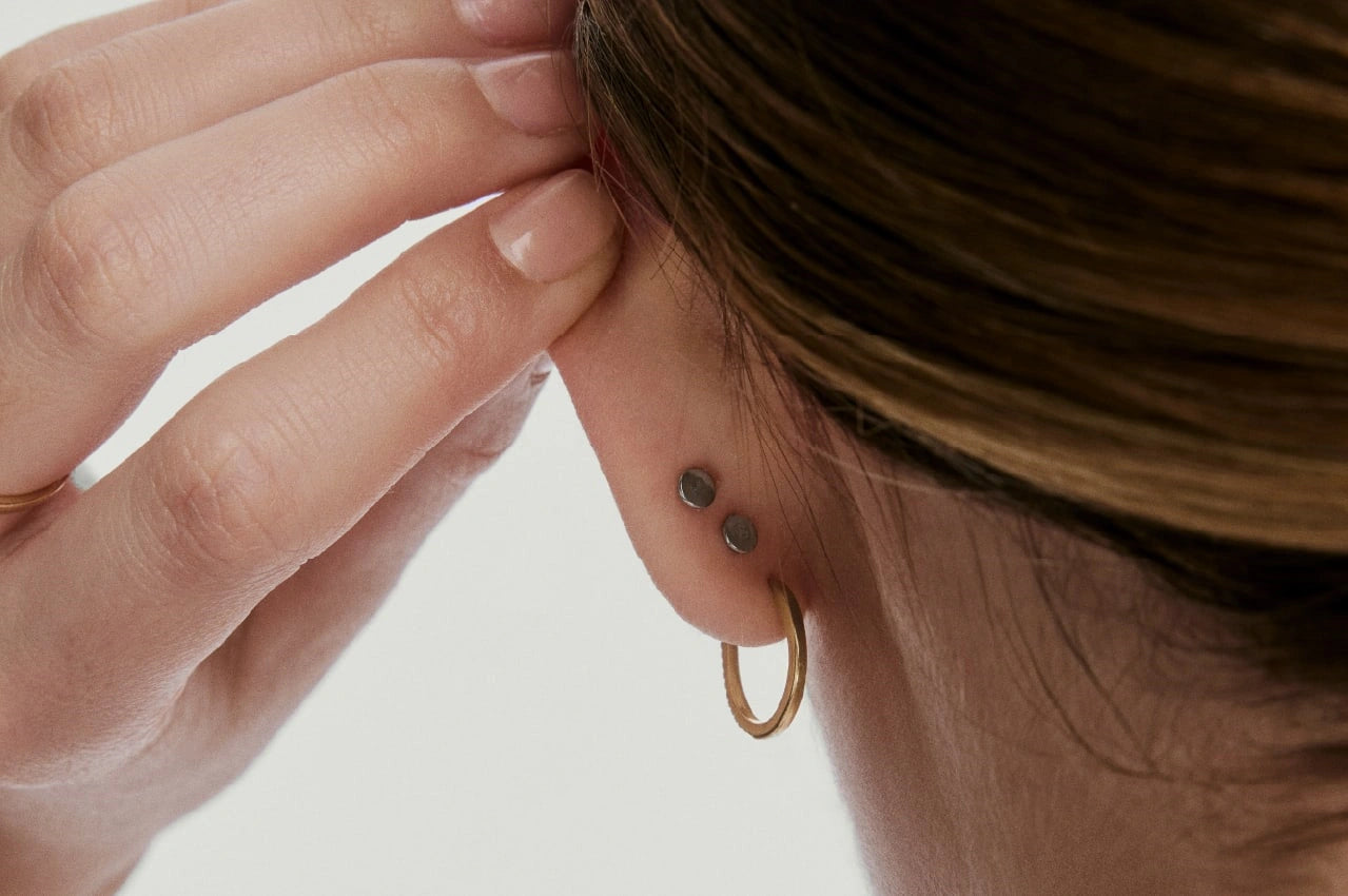 Close-up of a model wearing hoop earrings and studs, showing earring fit for the LeMing jewelry size guide.