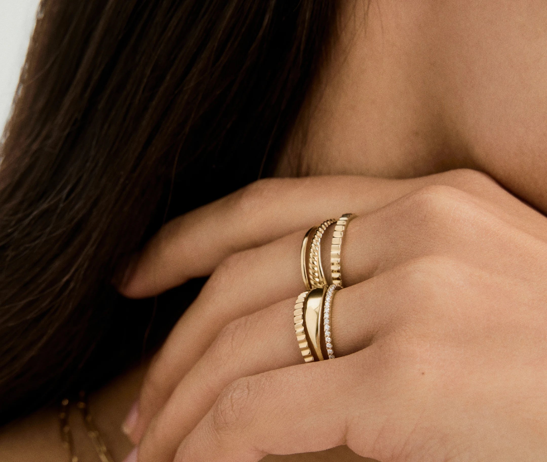 Gold stacked rings worn on a model’s hand, showing ring fit and styling for the LeMing jewelry size guide.