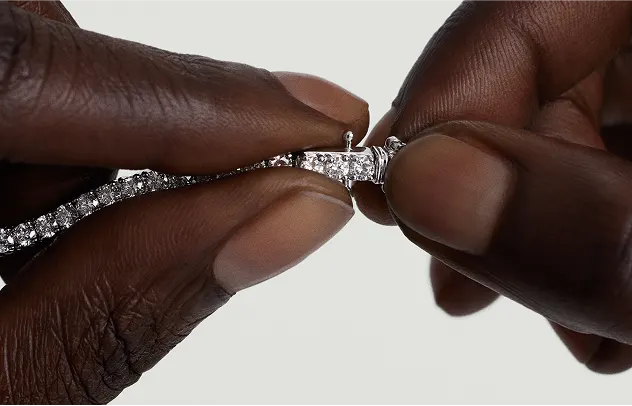 Close-up of a tennis necklace clasp being secured by hand, showing how to fasten a LeMing tennis necklace clasp.